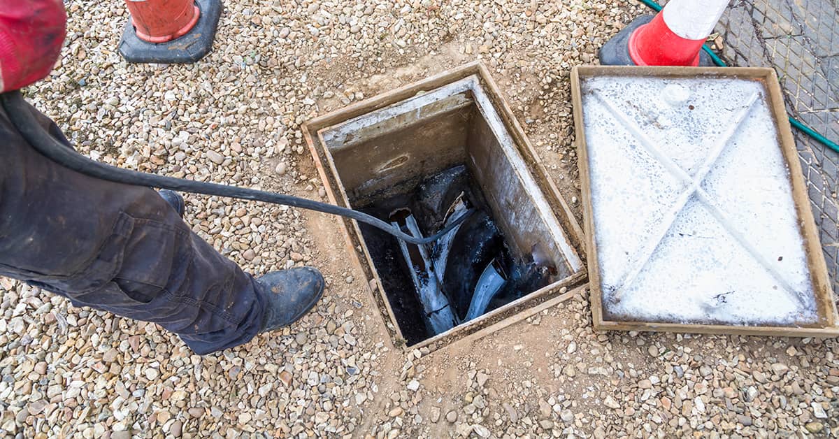 Expert using jetters to clear a blocked drain.