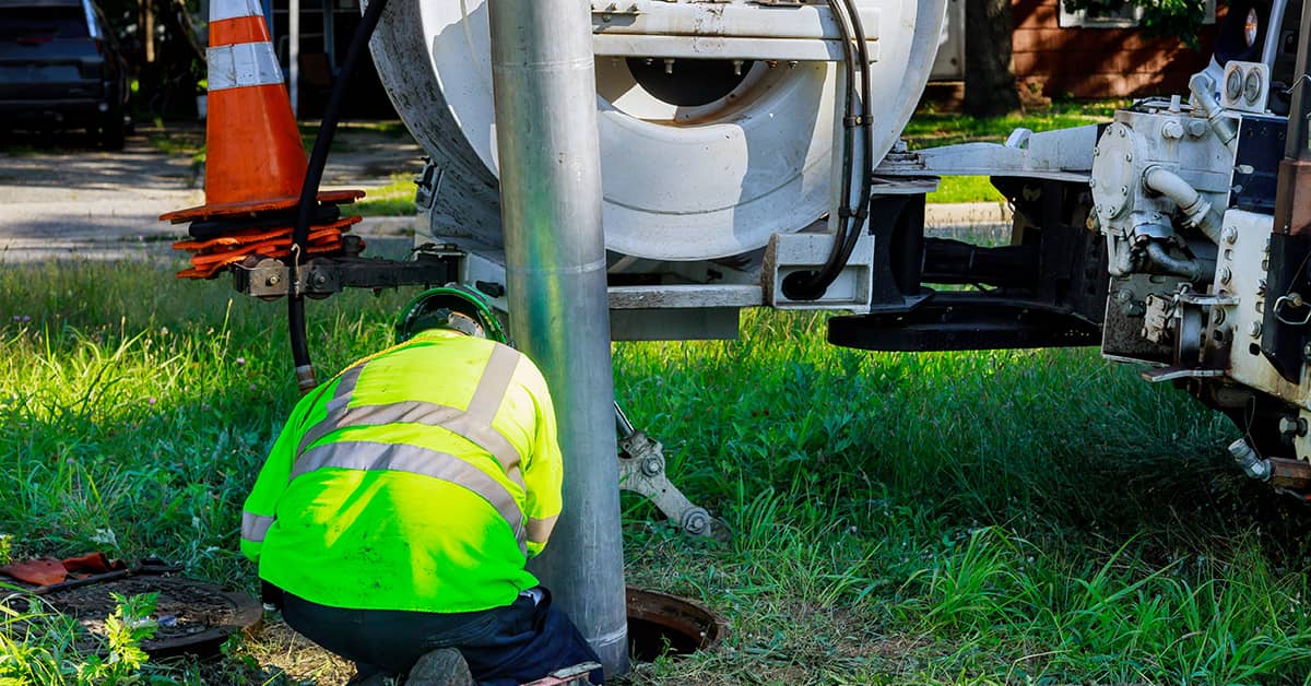 Drainage engineer operating a tanker for large-scale drain cleaning.