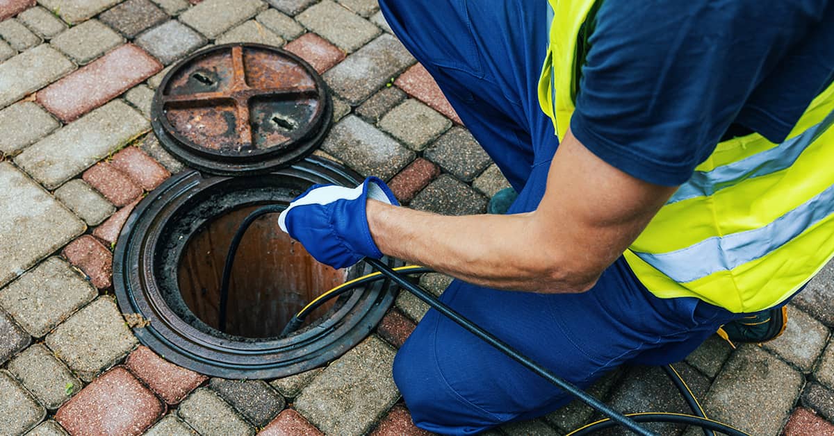 Advanced Drain Inspection: Camera Technology at Work Drainage engineer deploying a camera to inspect the interior of a drain.
