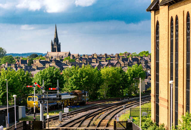 A view of Harrogate Train Station with railway tracks and St. Wilfrid’s Church in the background. Unblockers.net provides expert drain unblocking services throughout Harrogate to keep drainage systems running smoothly.