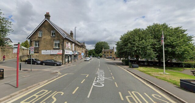 Pudsey – Reliable Local Drain Unblocking Services | Unblockers.net Street view in Pudsey, West Yorkshire, showing local businesses, road markings, and a nearby park. Unblockers.net offers expert drain unblocking services throughout Pudsey.