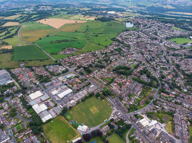 Aerial photograph of Yeadon, West Yorkshire, including cricket grounds, homes, and surrounding countryside. Unblockers.net provides 24/7 professional drain unblocking services across Yeadon.