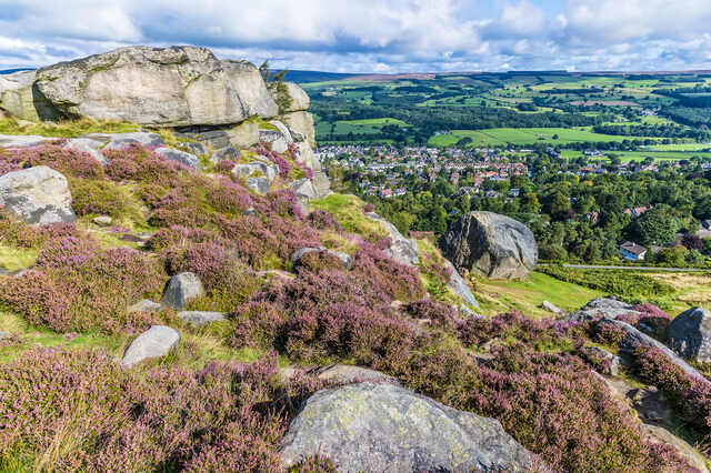 Ilkley Moor with heather-covered rocks and a panoramic view over Ilkley town. Unblockers.net provides professional drain unblocking services throughout Ilkley with 24/7 availability and upfront pricing.